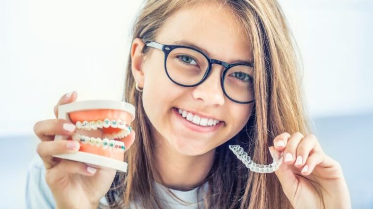 Teenager mit Zahnspangenmodell und Schiene